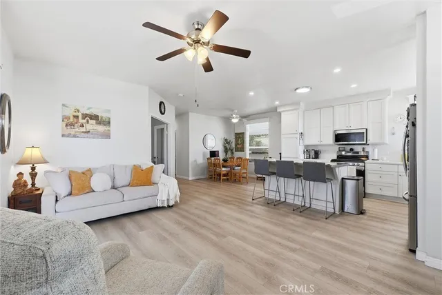 a living room with furniture kitchen view and a chandelier