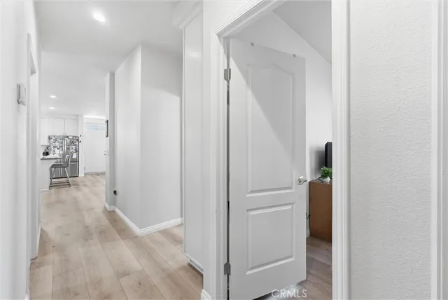 a view of a hallway with wooden floor and staircase