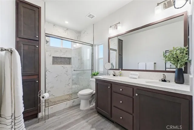 a bathroom with a double vanity sink toilet and shower