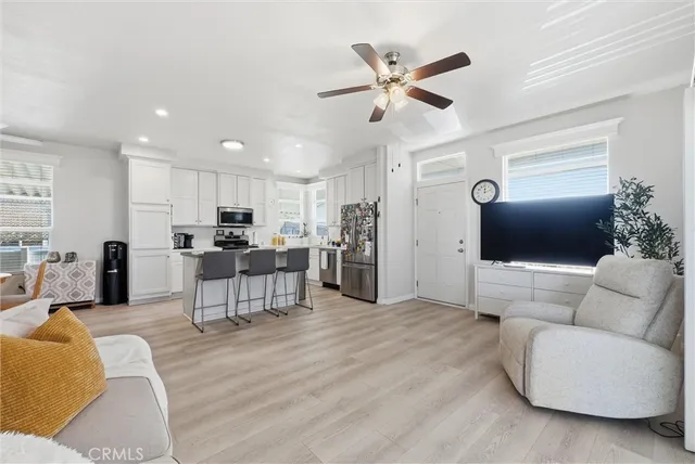 a living room with furniture and a view of kitchen