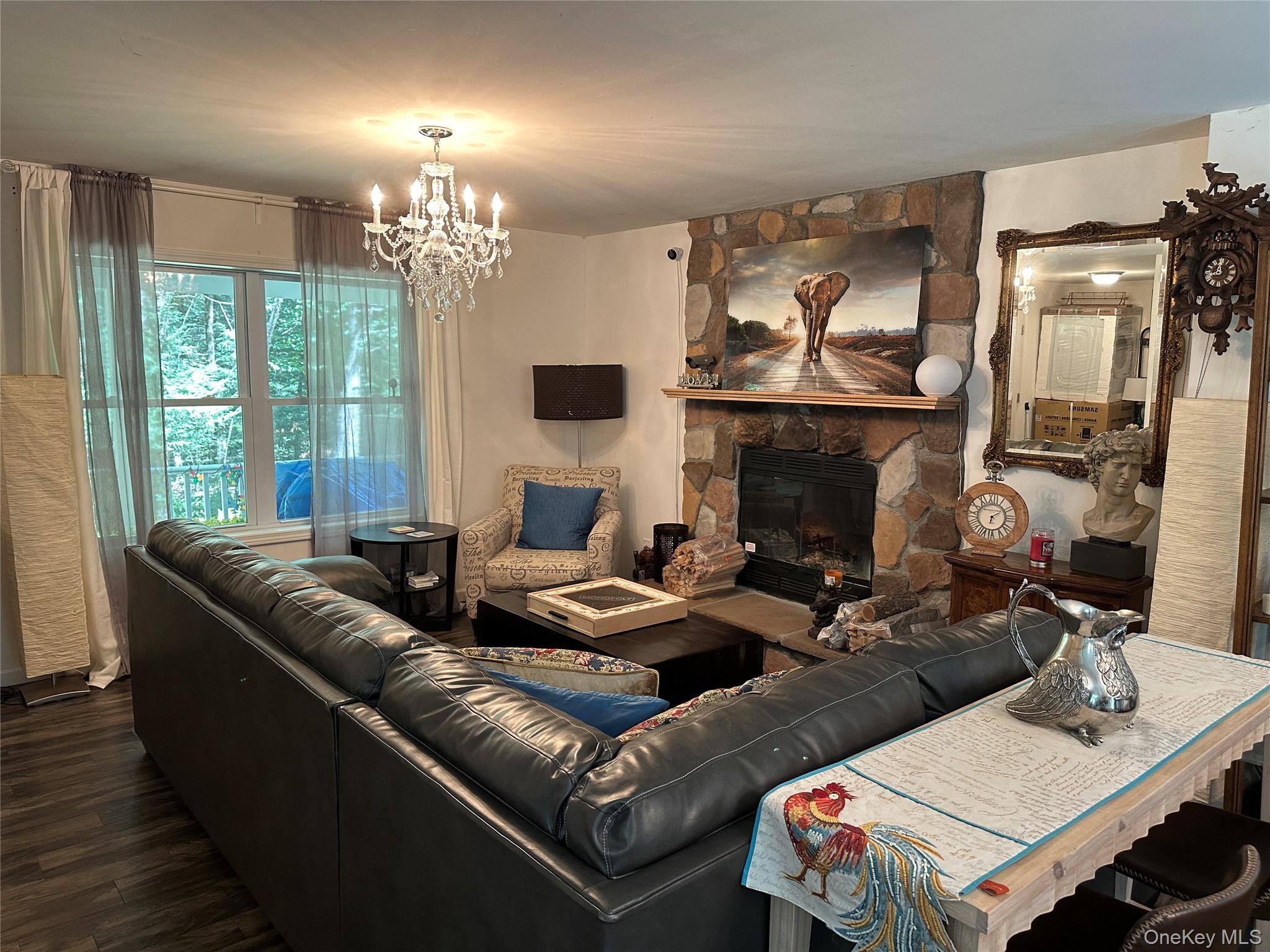 64 Schleiermacher Road Livingston Manor, NY 12758 - Photo 17 of 37 a living room with furniture a chandelier and a fireplace