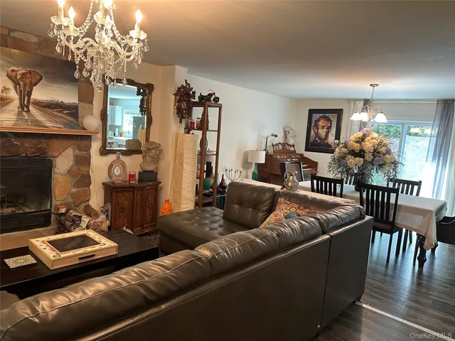 a living room with furniture a chandelier and a flat screen tv