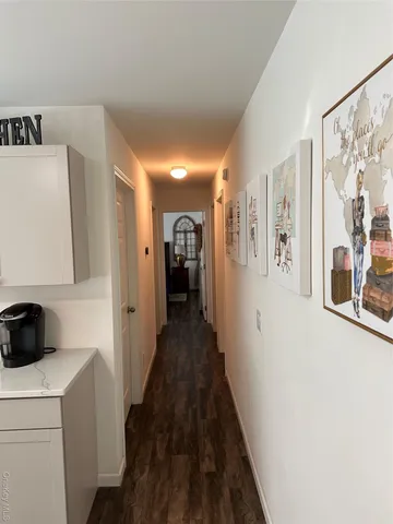 a view of a hallway with closet and wooden floor