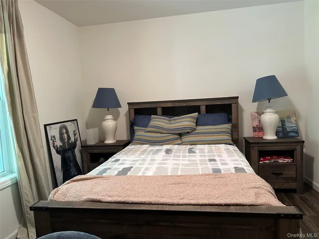 a bedroom with a bed and a lamp on dresser