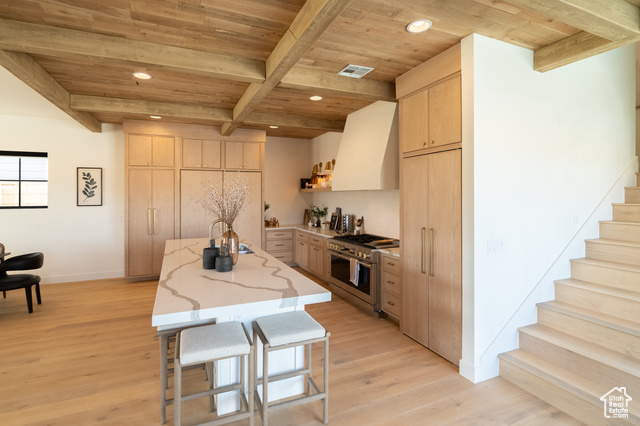 5366 Cyan Lane St. George, UT 84790 - Photo 10 of 39 Kitchen with light brown cabinetry, a wood ceiling with exposed beams, double oven range, wall chimney exhaust hood, and light wood-type flooring