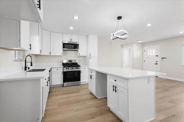 a kitchen with granite countertop white cabinets and white appliances