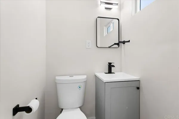 a bathroom with a toilet a sink and mirror