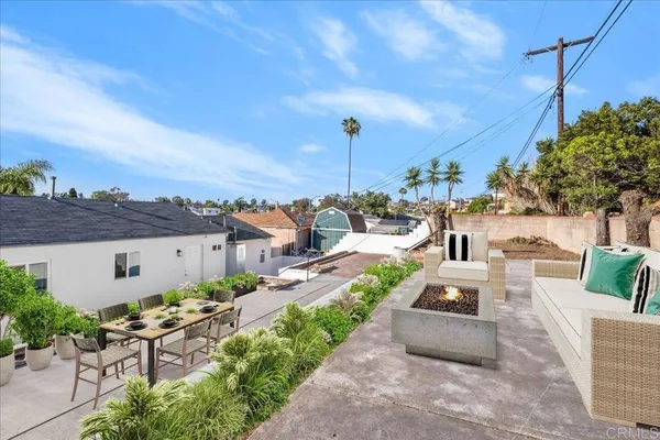 a view of a patio with couches table and chairs and potted plants