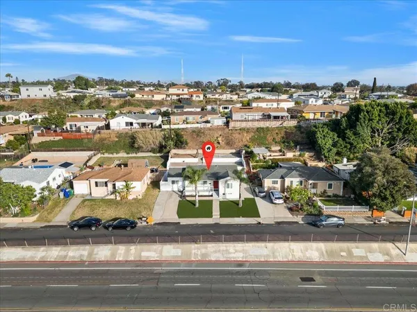 an aerial view of residential houses with outdoor space and parking