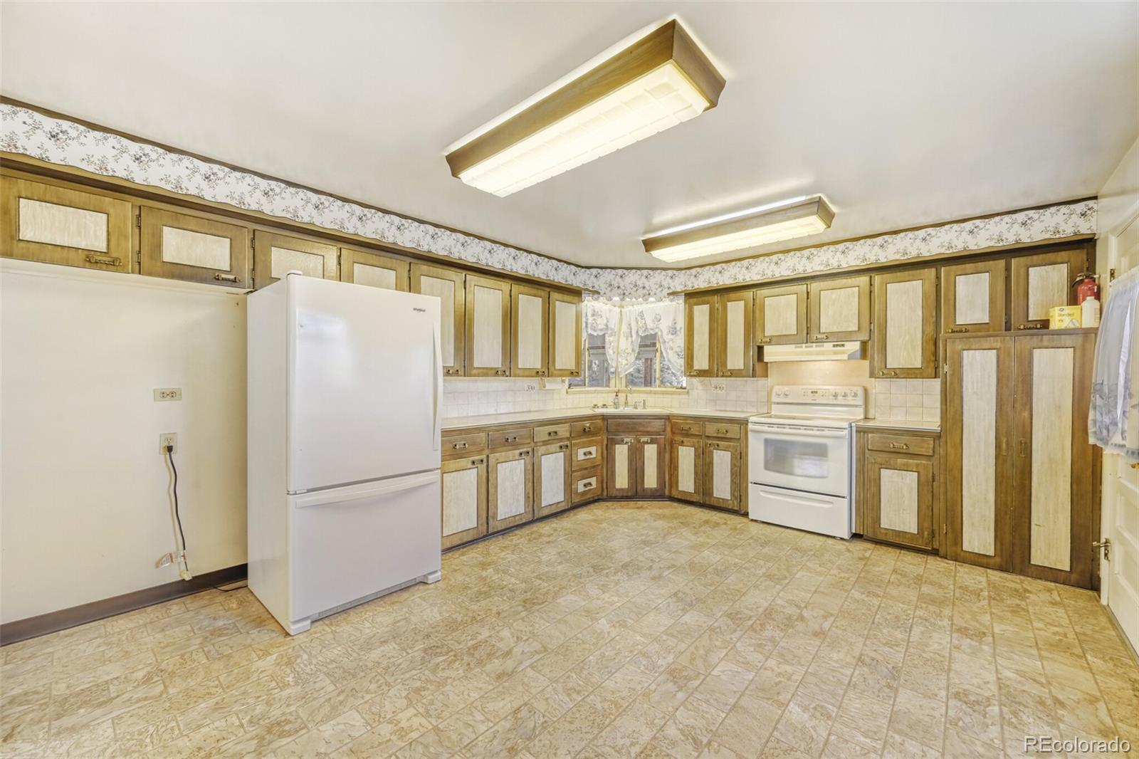 7850 Raleigh Street Westminster, CO 80030 - Photo 4 of 18 a large white kitchen with granite countertop a refrigerator and a stove top oven