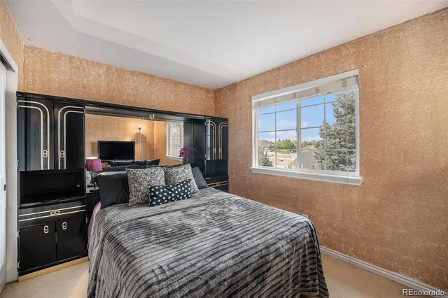 a bedroom with a large bed and a tv on dresser