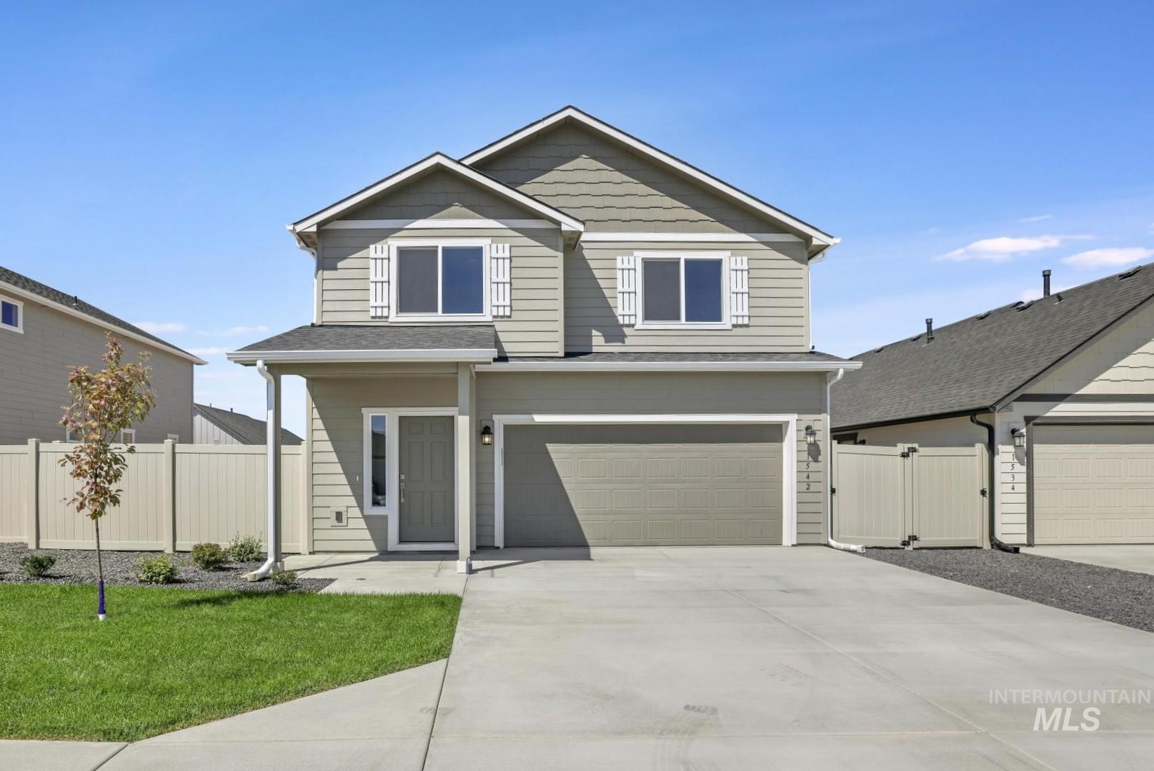 View of front facade with concrete driveway, a garage, and a gate