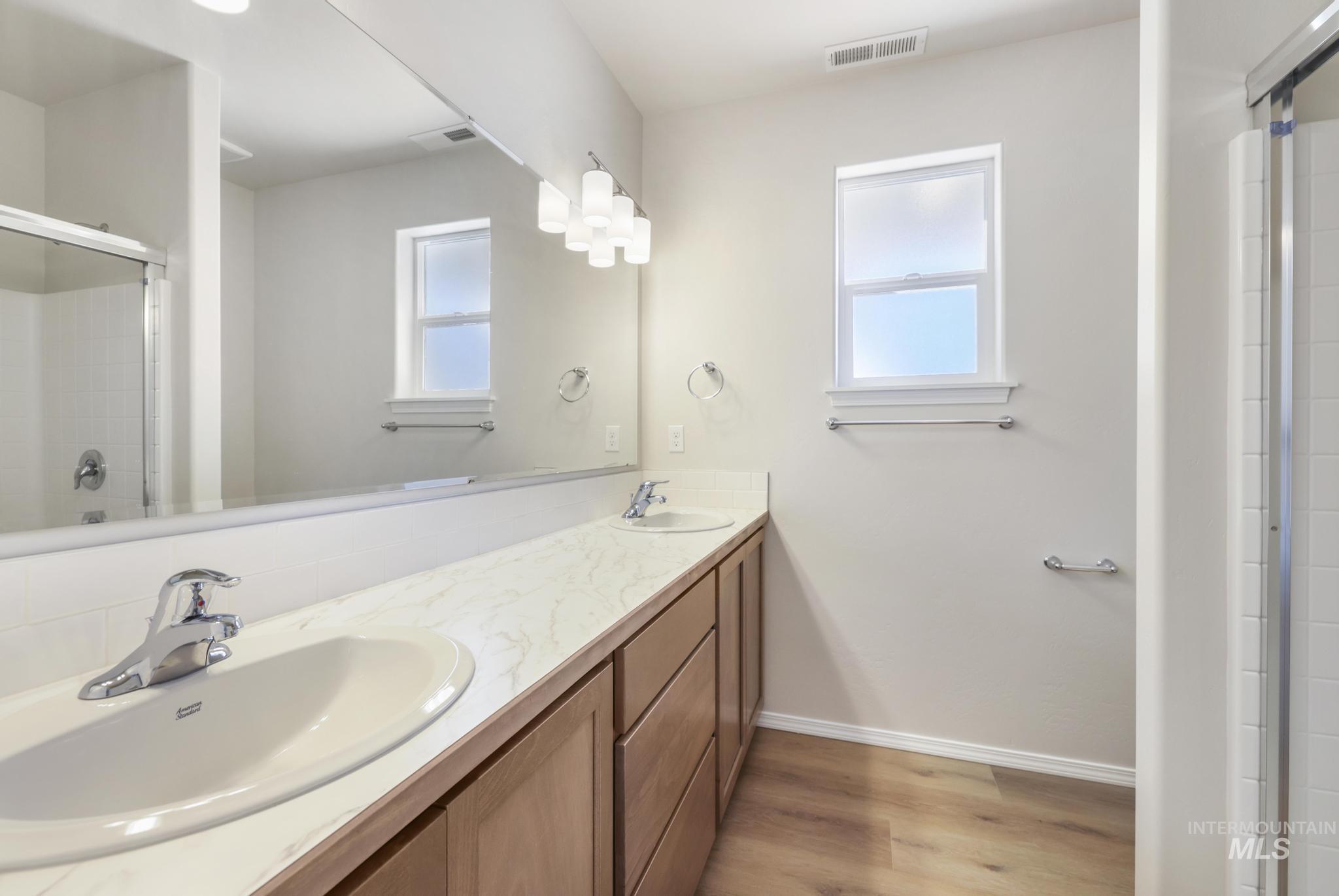1542 Kenyon Road Twin Falls, ID 83301 - Photo 18 of 26 Full bath with light wood-type flooring, double vanity, and an enclosed shower