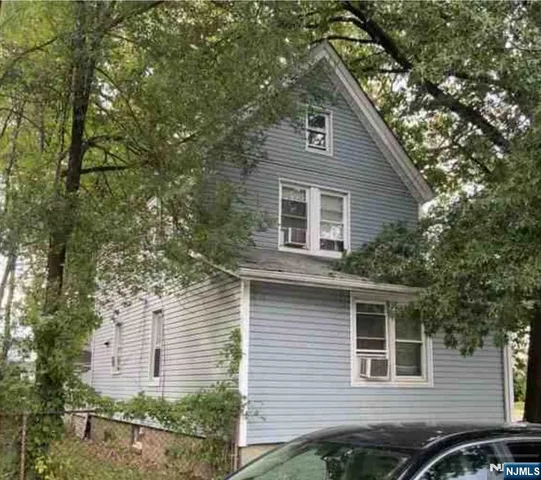 a front view of a house with a tree