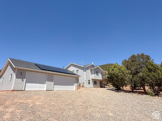 425 East Mule Deer Road Central, UT 84722 - Photo 44 of 72 View of front facade featuring solar panels, a garage, and an outbuilding