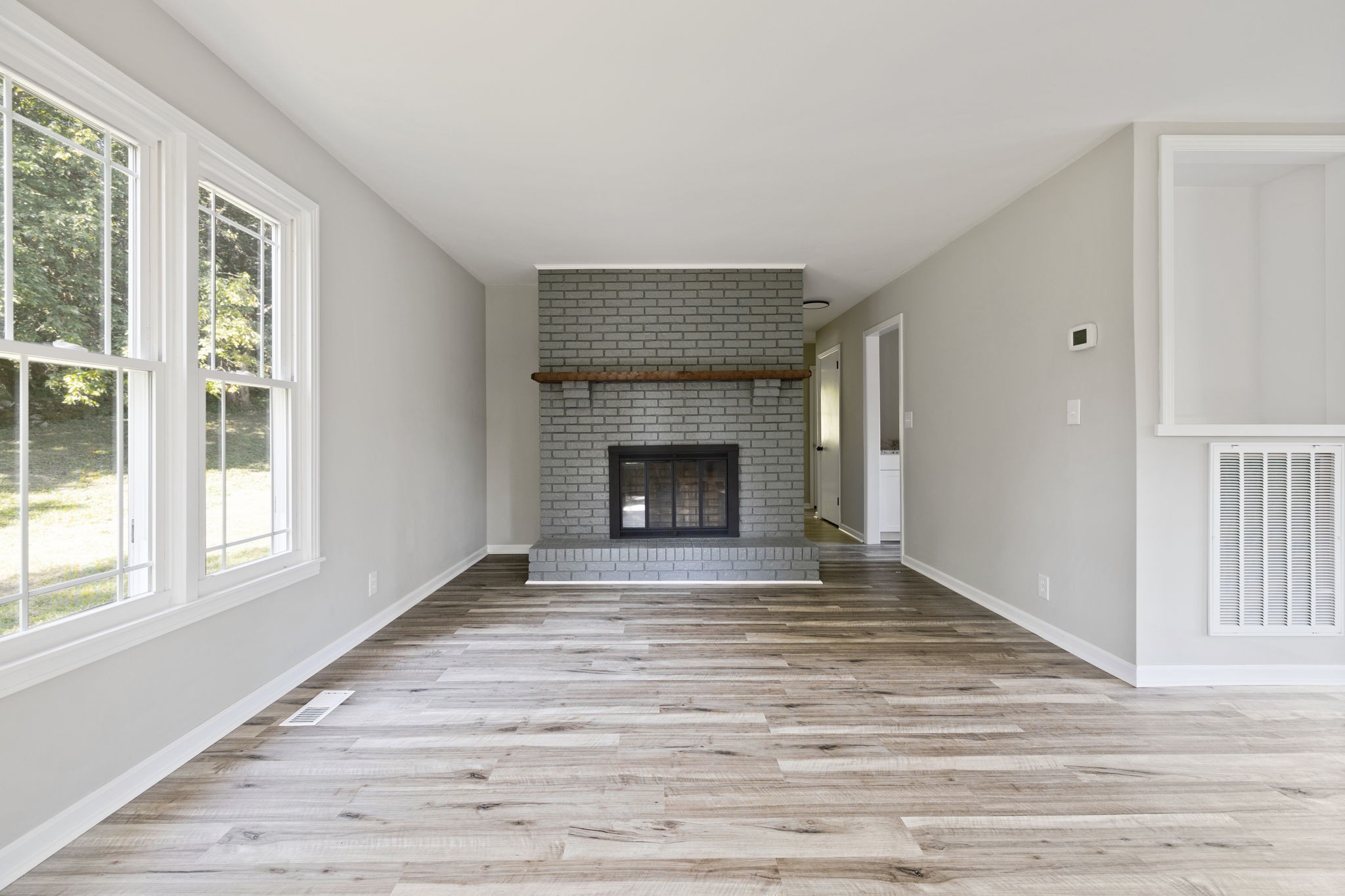 87 Gladdice Road Pleasant Shade, TN 37145 - Photo 12 of 47 a view of an empty room with wooden floor fireplace and a window