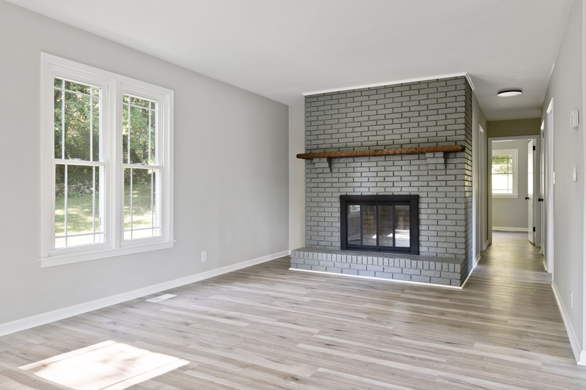 87 Gladdice Road Pleasant Shade, TN 37145 - Photo 16 of 47 a view of an empty room with wooden floor and a fireplace