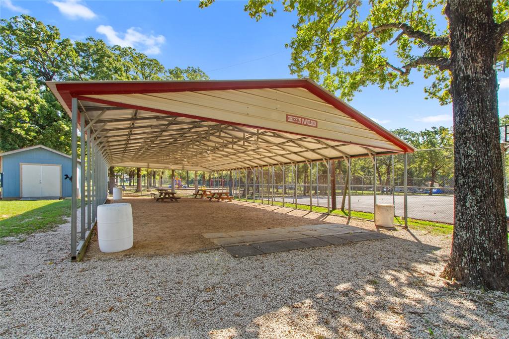 7520 Double Bridge Road Mabank, TX 75156 - Photo 24 of 32 Expansive covered pavilion with red metal roof and open-sided design, providing ample shade over gravel grounds