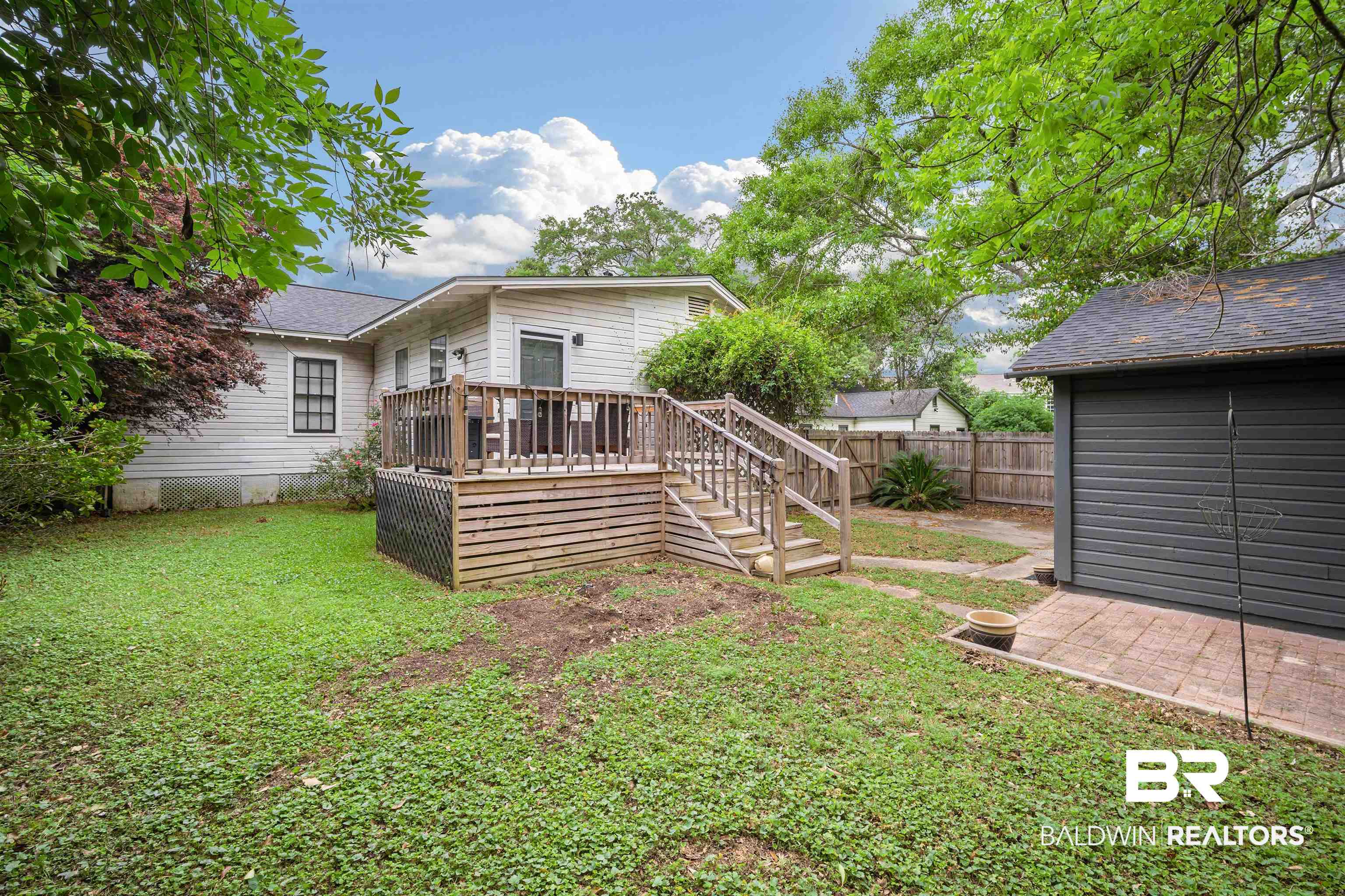 103 Emogene Place Mobile, AL 36606 - Photo 29 of 32 Rear view of house with a wooden deck, a fenced backyard, and roof with shingles