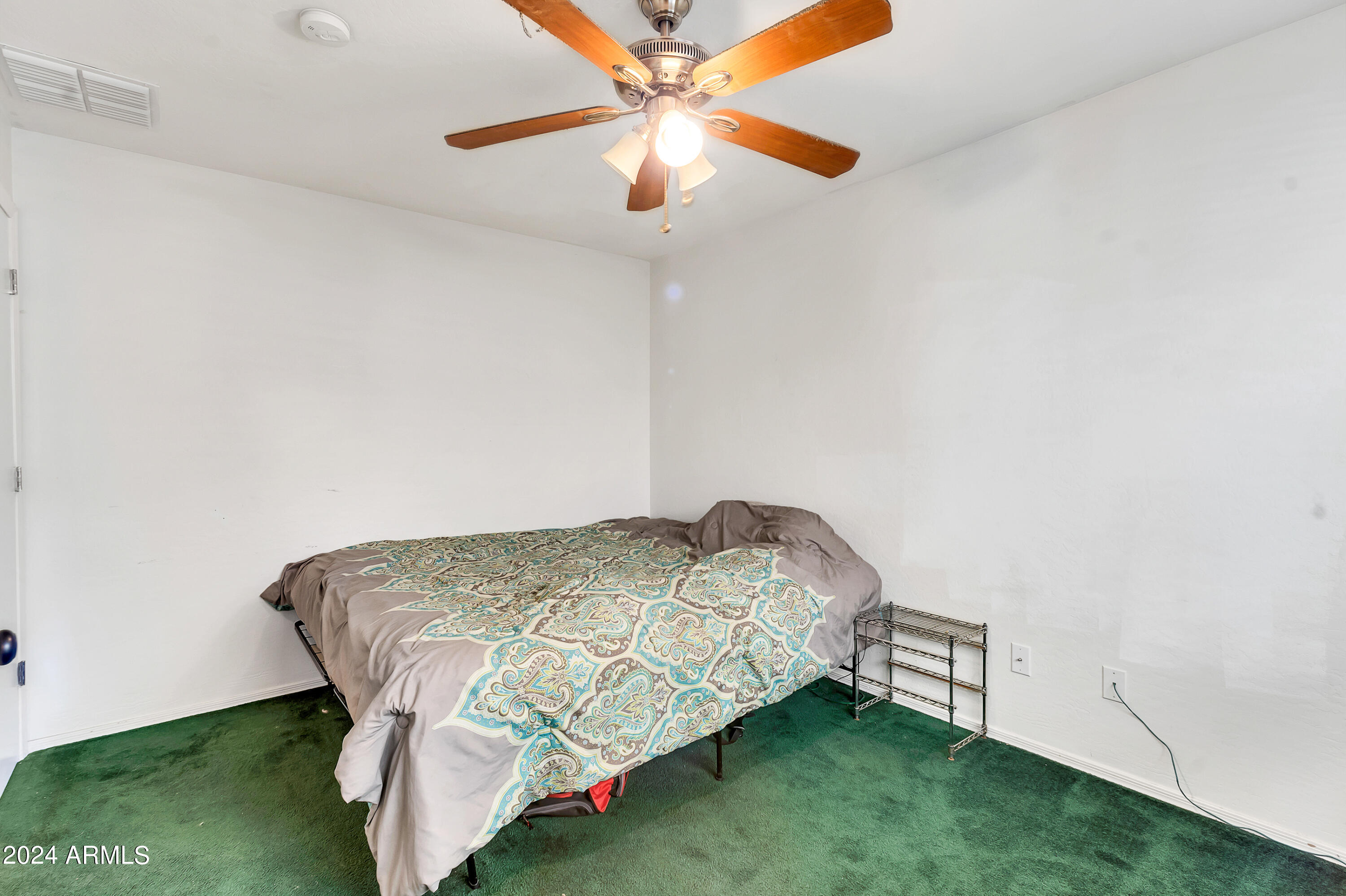 1215 West Ocotillo Street Coolidge, AZ 85128 - Photo 22 of 29 a bedroom with a bed and a chandelier