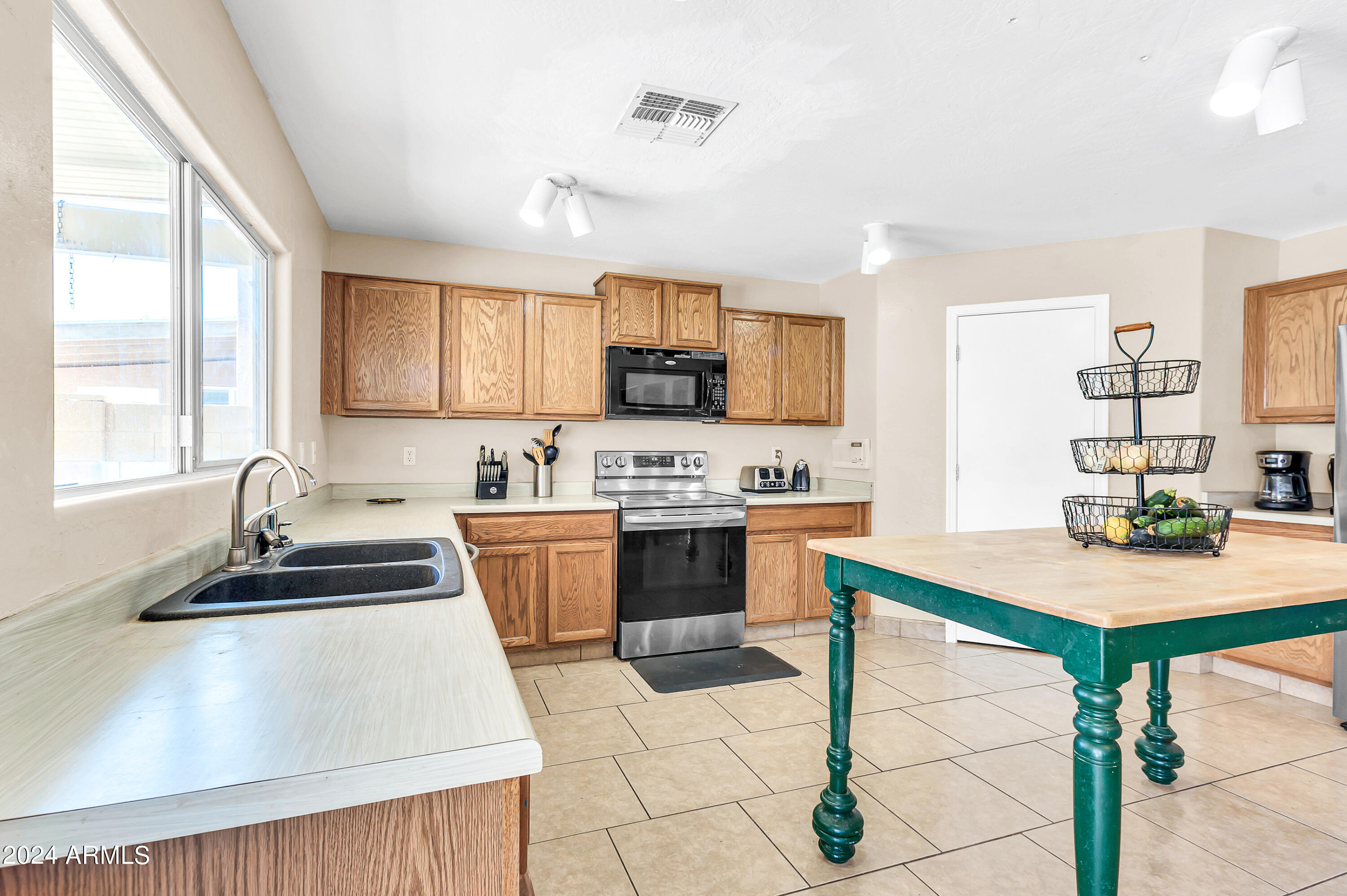 1215 West Ocotillo Street Coolidge, AZ 85128 - Photo 10 of 29 a kitchen with a stove a sink a microwave a dining table and chairs