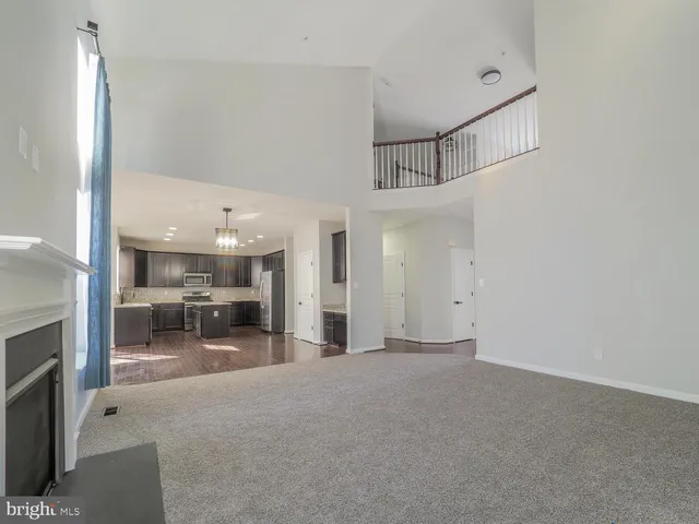 a view of a hallway with wooden floor and stairs