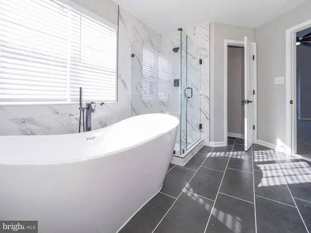 a bathroom with a sink a toilet a mirror and shower