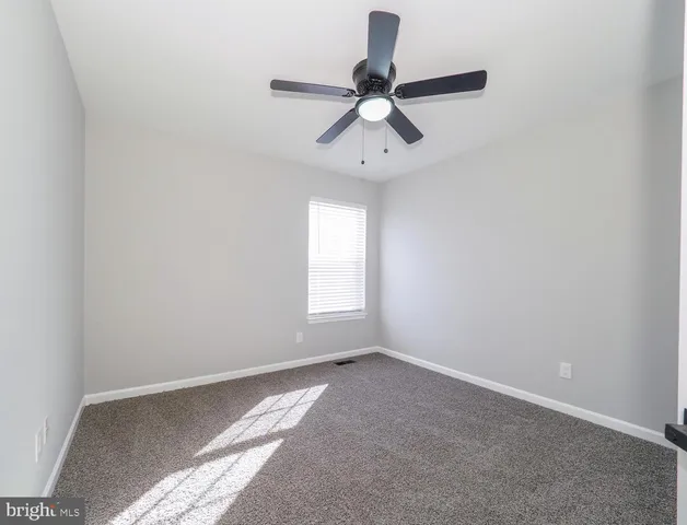 a view of a big room with windows and chandelier fan