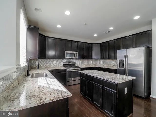 a large kitchen with kitchen island a refrigerator sink and stove