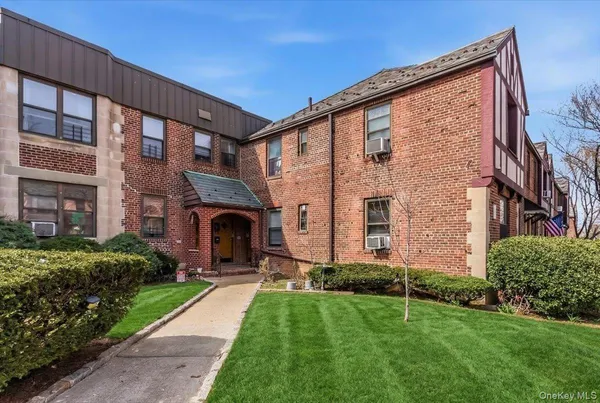front view of a brick house with a yard