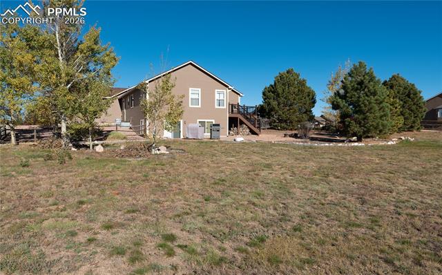 9385 Winged Foot Road Peyton, CO 80831 - Photo 43 of 50 Back of home with deck, patio, fire pit, backing to Antler Creek Golf Course