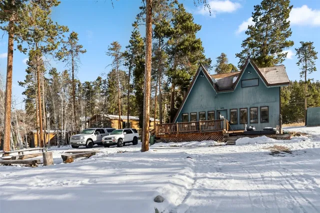 a view of road with card parked on side and retail shops