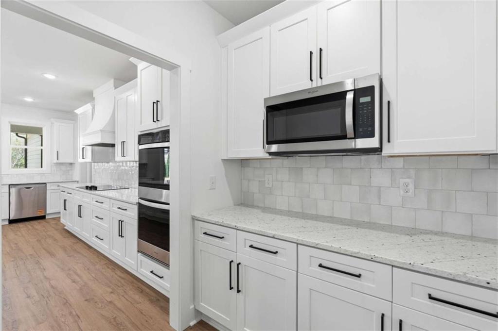 11691 Hazelbrand Road Northeast Covington, GA 30014 - Photo 18 of 53 a kitchen with stainless steel appliances white cabinets and a stove top oven