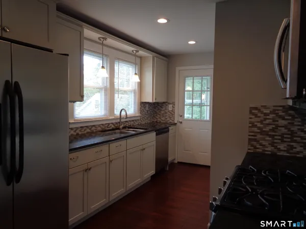a kitchen with granite countertop a refrigerator and a stove