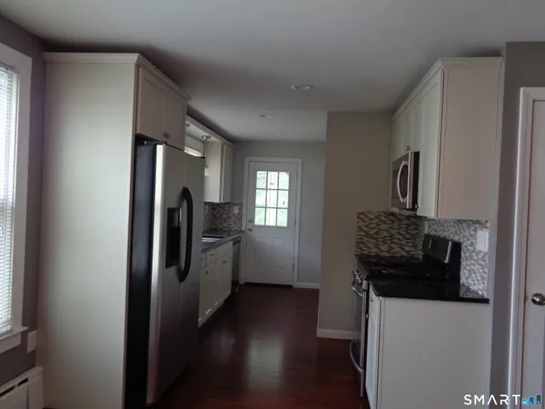a kitchen with a refrigerator and a stove top oven