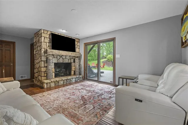 a living room with furniture a flat screen tv and a fireplace