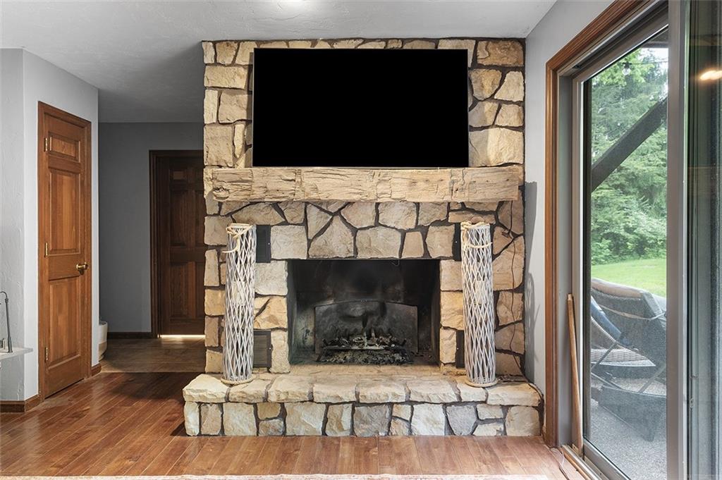6178 Baker School Road Trafford, PA 15085 - Photo 20 of 48 a living room with a fireplace a flat screen tv and a floor to ceiling window