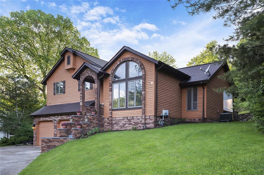 6178 Baker School Road Trafford, PA 15085 - Photo 2 of 48 a front view of a house with a garden and plants
