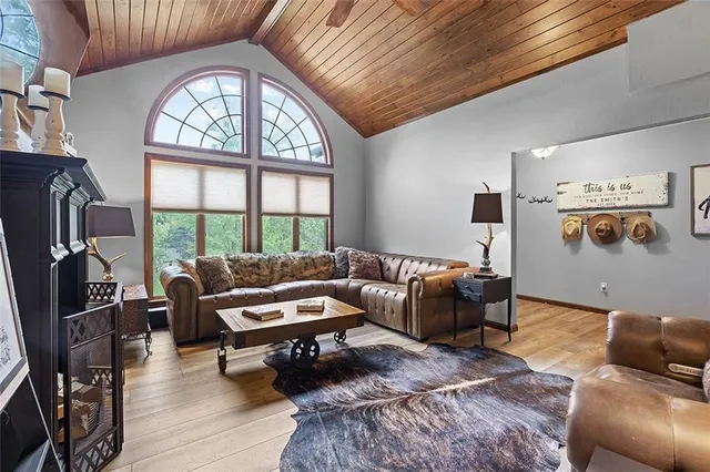 a living room with furniture a fireplace and a floor to ceiling window