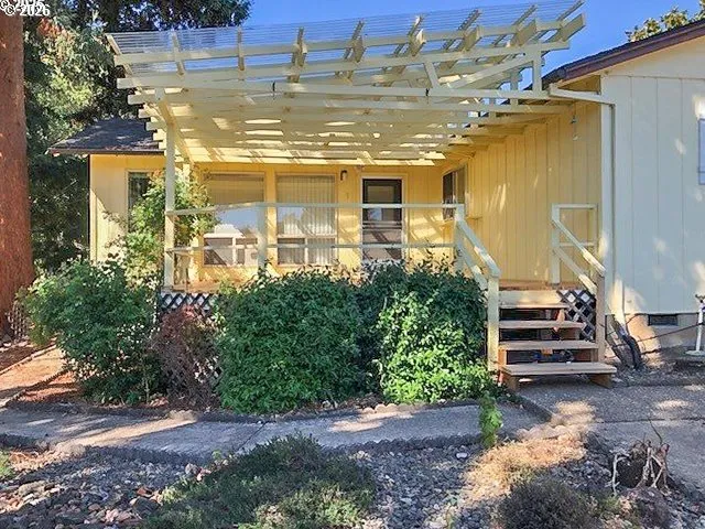 a view of a yard with plants and wooden fence
