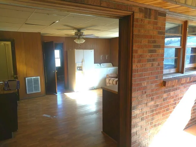 a view of a hallway with wooden floor and a living room