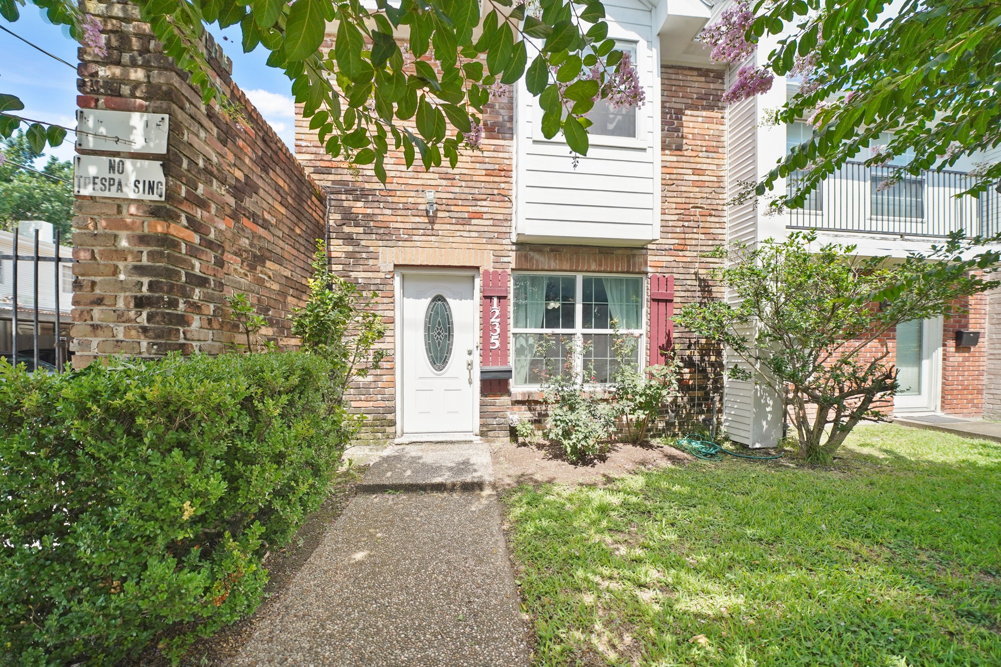 1235 Witte Road, Unit 8 Houston, TX 77055 - Photo 1 of 20 a view of a house with brick walls and a yard with plants