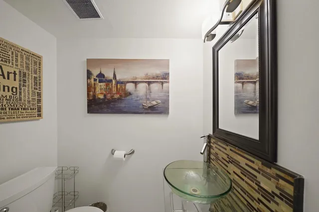 a bathroom with a toilet a sink and mirror