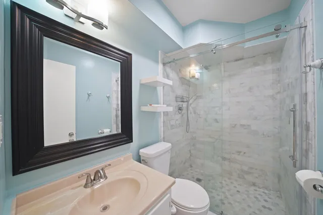 a bathroom with a sink a toilet and shower