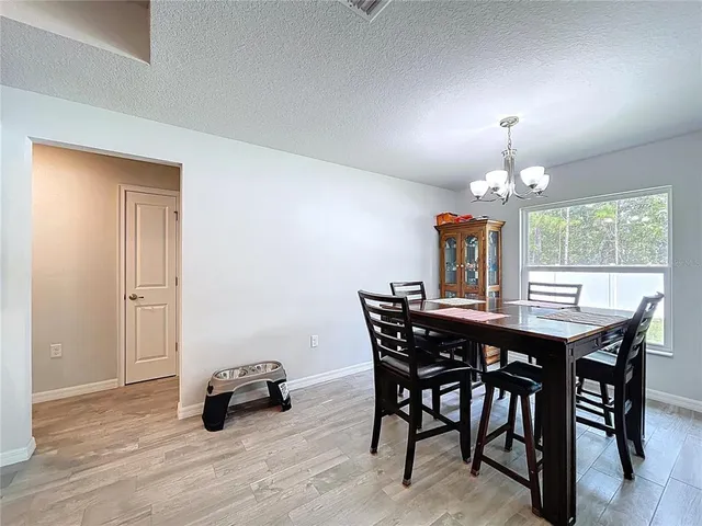 a view of a dining room with furniture and chandelier