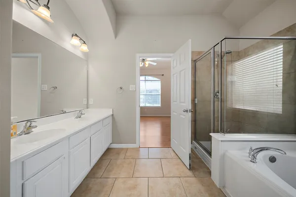 a bathroom with a double vanity sink and mirror with shower
