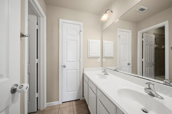 a bathroom with a double vanity sink a mirror and a bathtub