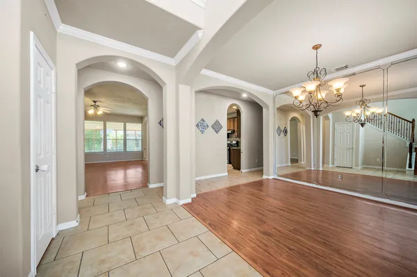 a view of a hallway with wooden floor and a large mirror