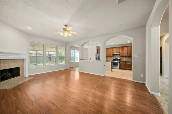 a view of a kitchen and an empty room with wooden floor kitchen view
