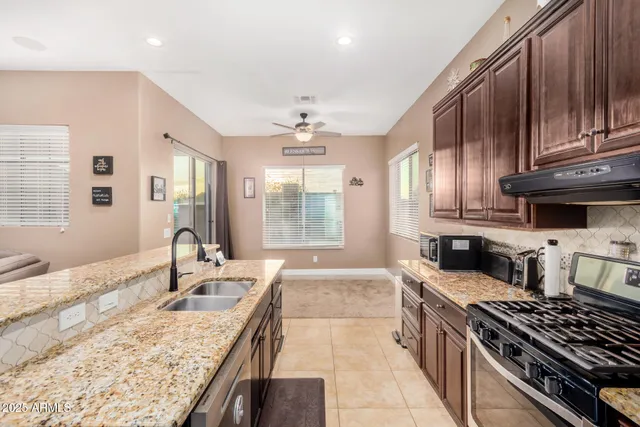 a kitchen with stainless steel appliances granite countertop a sink stove and cabinets